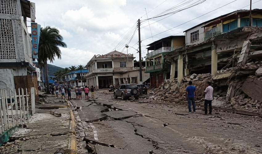 Rua danificada e prédios destruídos após um forte terremoto, destacando a importância de um sistema de alerta de terremotos.